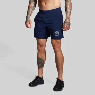 The Versatile Short (Navy Blue) treningsshorts med innershorts. Mann med mørkeblå trenings-shorts med lommer og innertights. Innertightsen har lomme på én side.