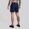 Mann med mørkeblå trenings-shorts med lommer og innertights. Innertightsen har lomme på én side.