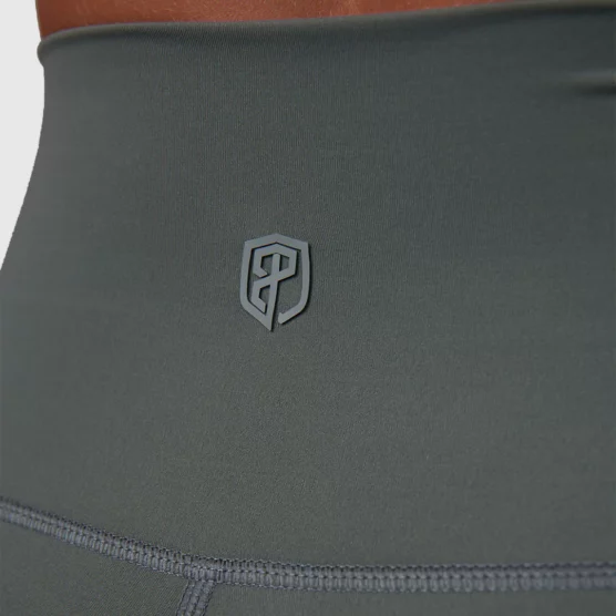Korsryggen til en dame i grå tights i teknisk stoff. Bildet har et utsnitt av livet og viser Born Primitives logo i den samme fargen som tightsen.