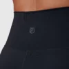Korsryggen til en dame i sort tights i teknisk stoff. På korsryggen er det Born Primitives logo i den samme fargen som tightsen.