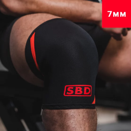 sbd 7mm knee sleeves, Kneet til en mann som har på knee sleeves fra SBD. Knee sleevsene er sorte og det står SBD i en rød firkant i rødt nederst foran.