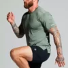 Mann i løpepositur med grønn t-skjort og sort shorts.