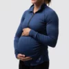 mammagenser, En gravid dame i blå genser i teknisk stoff som står skrått vendt mot kameraet. Genseren har en sort halfzip-glidelås i halsen.