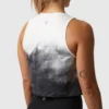 Dame i sort og hvit cropped topp i teknisk stoff som står med ryggen mot kameraet.