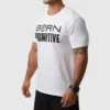 Mann i hvit t-skjorte som står skrått vendt mot kameraet. Det står "Born Primitive" med sort tekst på brystet.