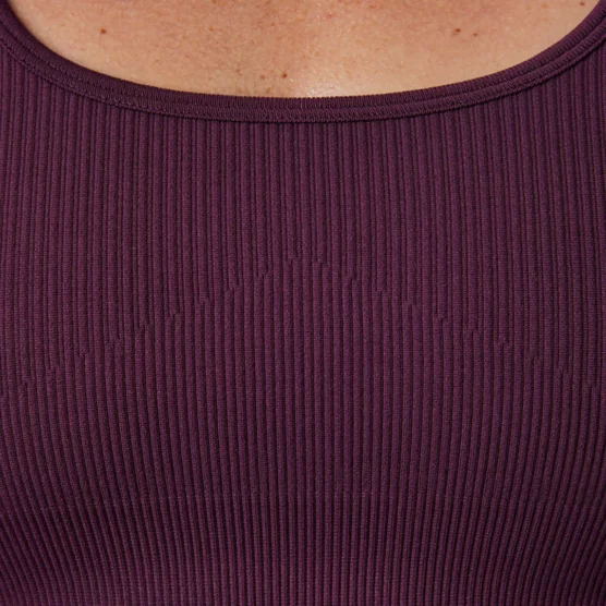 Bildet viser et lite utsnitt av brystet til en dame i kirsebærfarget sports-bh. Sports-bhen er ribbestrikket.