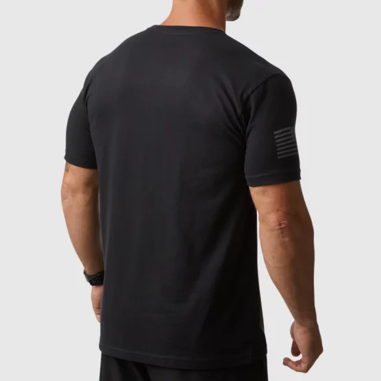 Mann i sort t-skjorte i teknisk stoff med ryggen mot kameraet. T-skjorten har gra striper på siden på det høyre ermet.