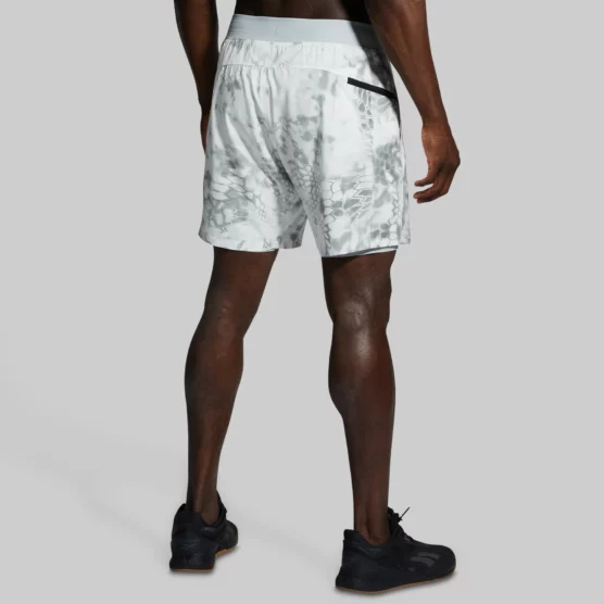 Mann i hvit shorts med gråspraglete mønster med ryggen til. Shortsen har glidelåslomme på høyre side bak.