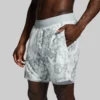Mann i hvit shorts med et gråspraglete mønster. Shortsen har en hvit innershorts.