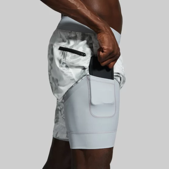 Mann i hvit shorts med et gråspraglete mønster. Shortsen har en hvit innershorts med integrerte lommer.