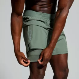 Mann iført grønn shorts, med innebygd kompresjonstights