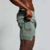 Mann avbildet sidelengs iført grønn shorts, med innebygd kompresjonstights. Han demonstrerer at tightsen har en plass til en telefon i lommen.