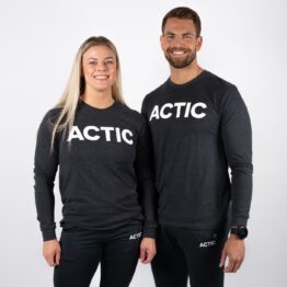actic long sleeve, Mann og kvinne avbildet forfra iført mørk grå langermet genser, med ACITC skrevet i hvit over brystet.