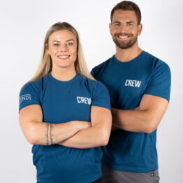 Mann og kvinne avbildet forfra med armene i kryss, iført blå t-skjorte med skriften CREW skrevet i hvit på venstre bryst.