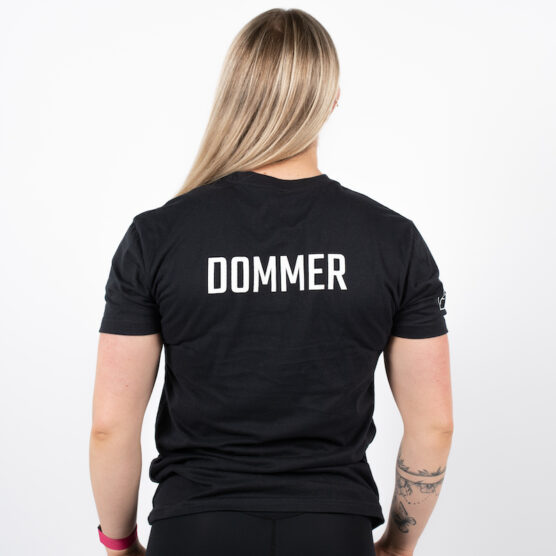 Kvinne avbildet bakfra iført sort t-skjorte med DOMMER skrevet i hvit på ryggen