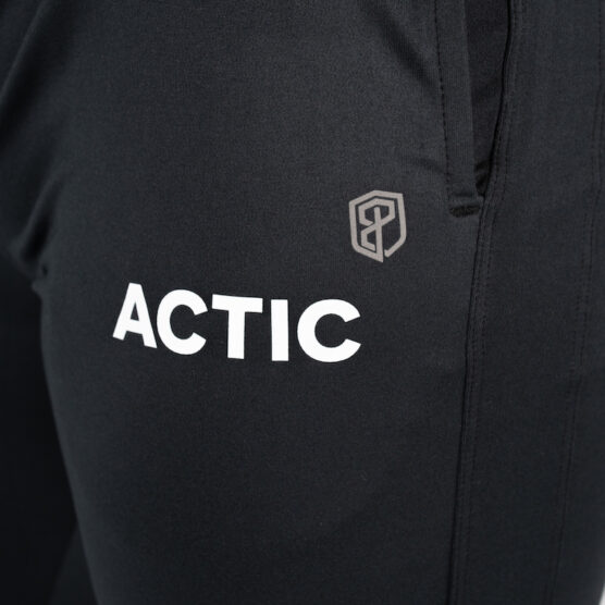 Detaljbilde av ACTIC logo skrevet i hvit, øverst på venstre lår på bukse