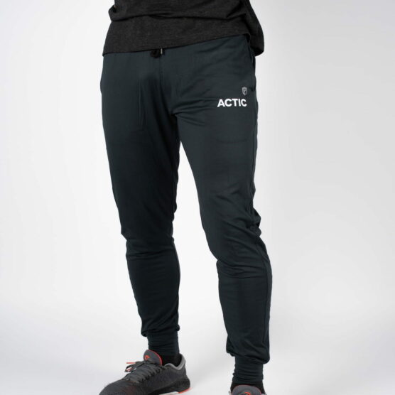 actic joggebukse, beina til en mann fotografert forfra iført en sort bukse med teksten ACTIC skrevet i hvit øverst på venstre lår