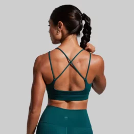exhale sports bra, Kvinne med mørkegrønn sports-BH. Sports-BHen har kryssende stropper på ryggen.