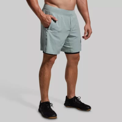 versatile short. Mann med lys grå trenings-shorts med lommer. Shortsen har innertights med lomme på én side.