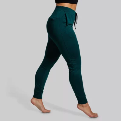 joggebukse, Kvinne med mørkegrønn joggebukse med lommer foran og bak. Buksen har knyting i livet.