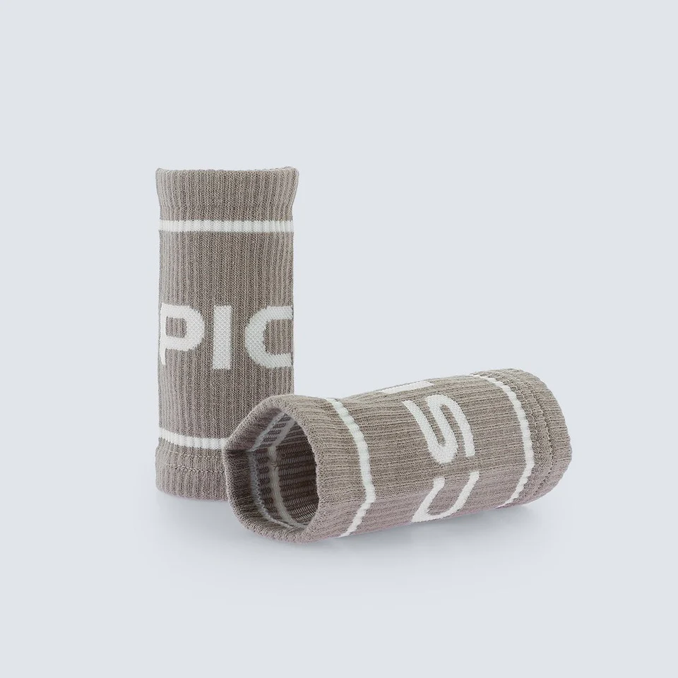 Wristbands til trening fra Picsil. De er brune med hvite striper og teksten "Picsil" i hvit farge.