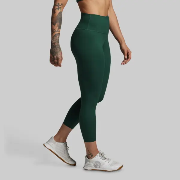 Your Go To Legging 2.0 (grove) treningstights til damer, bilde viser beina av dame som har på seg disse grønne tights og hvit born primitive treningssko